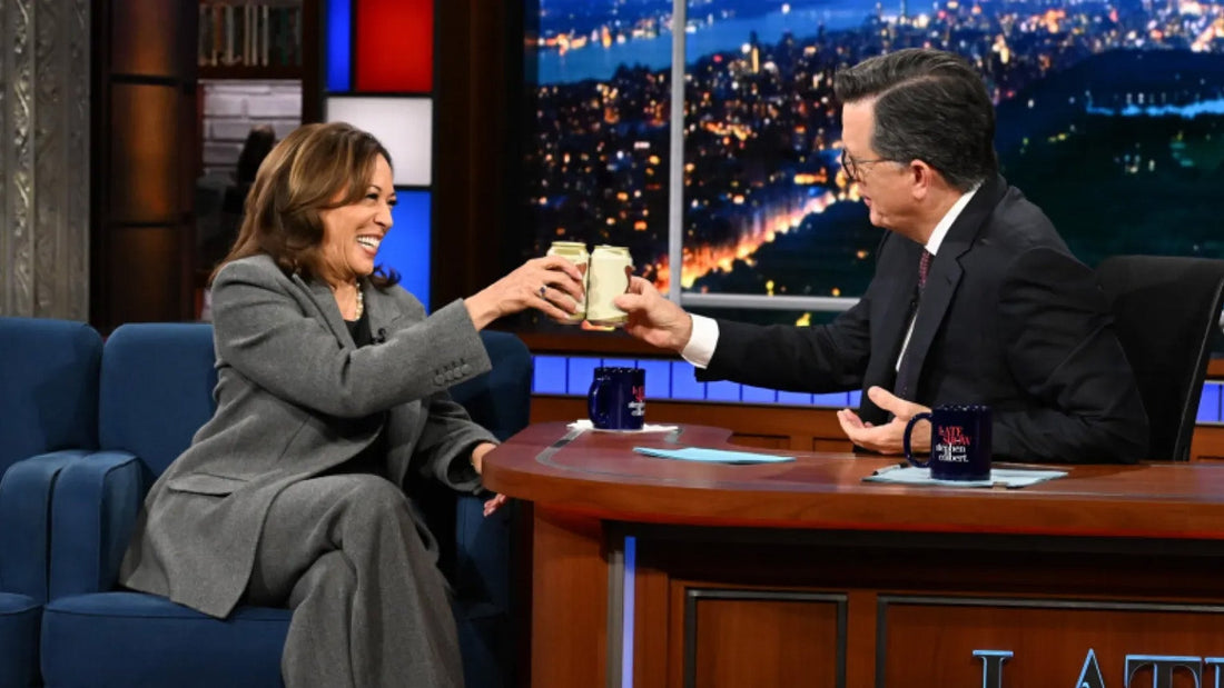 Kamala Harris drinking a beer with Stephen Colbert on The Late Show on CBS.